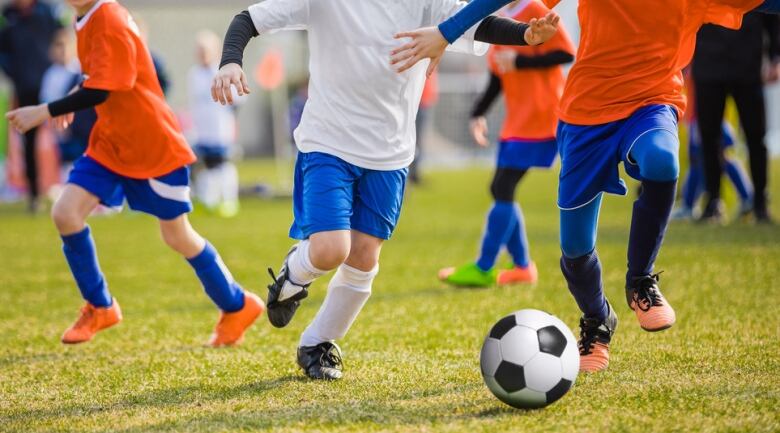 Children play soccer on a field.