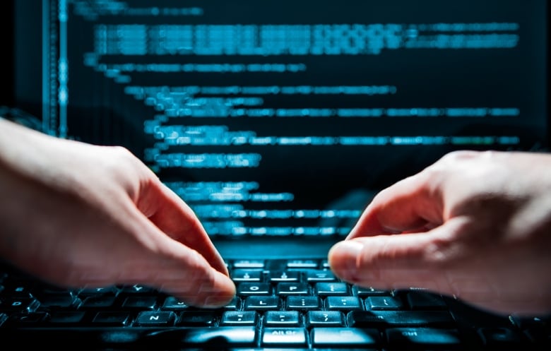 A pair of hands typing on a green and black keyboard. 