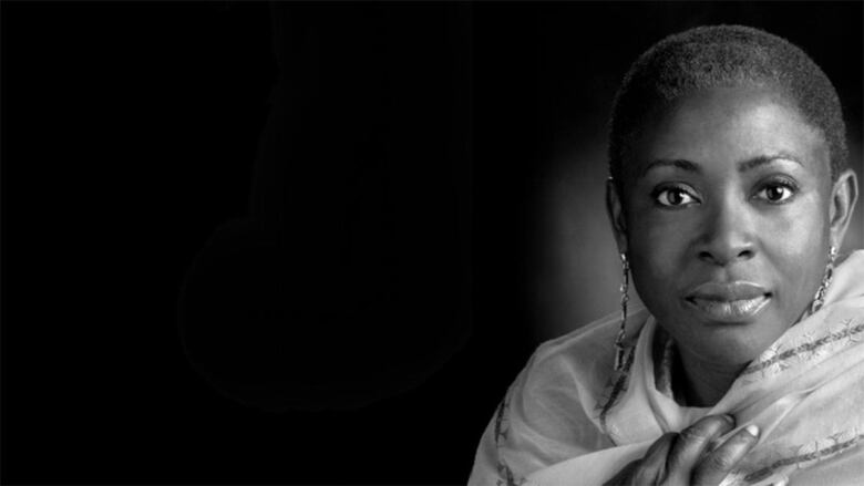 A black and white photo of a Black woman wearing long earring and a shawl