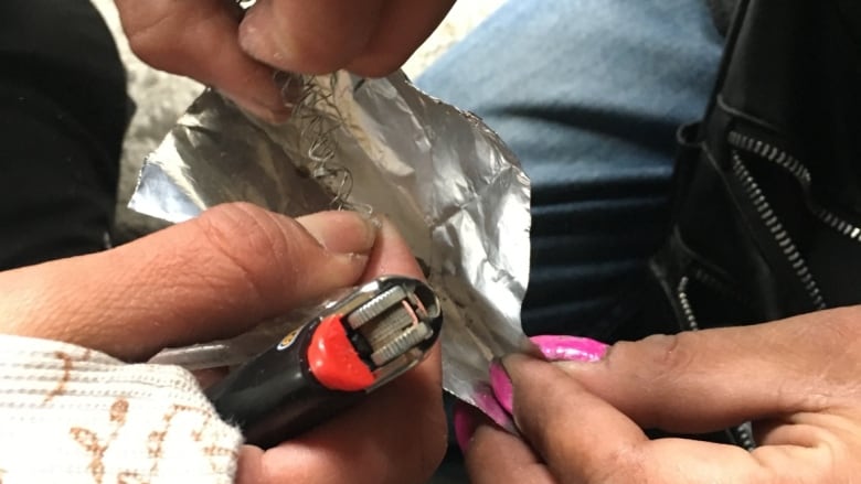 Close-up image of hands, foil and a lighter.