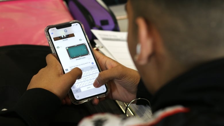 Teen student looking at his smart phone.