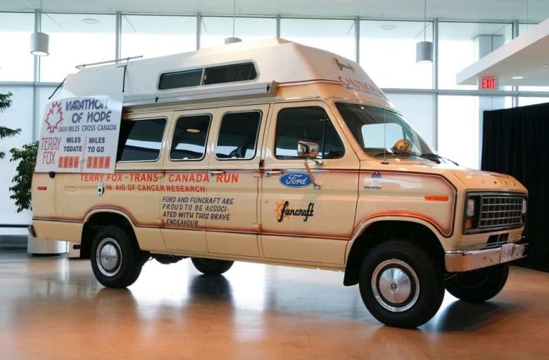 A beige van sits in a showroom.