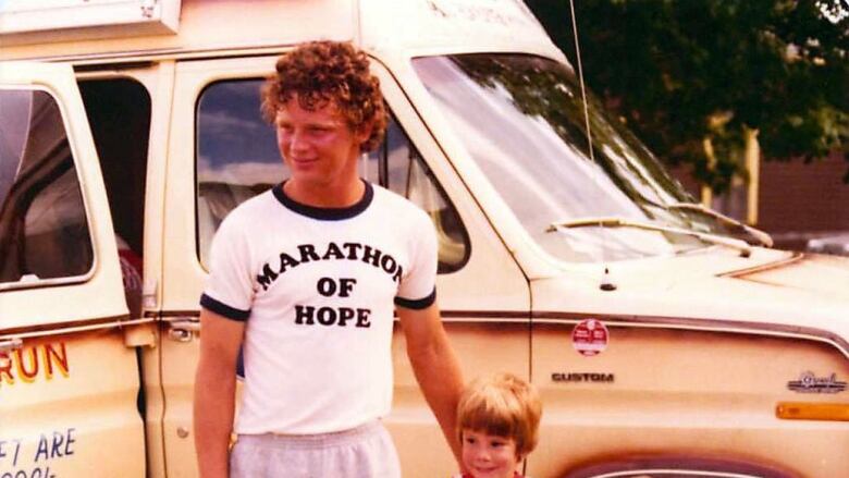 A man poses with two small children.