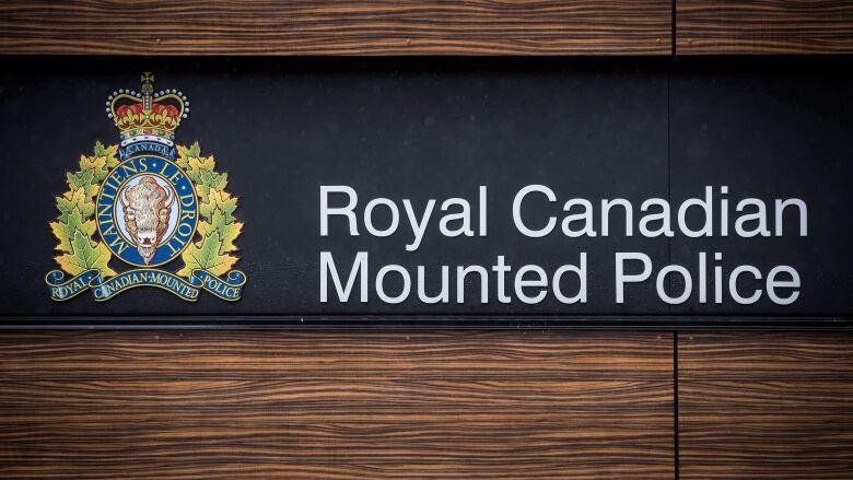 An RCMP logo is shown on a wood panel wall.