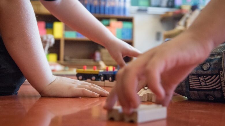 a child and an adult play with blocks 