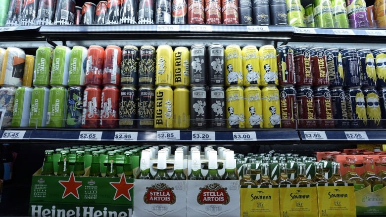 A row of shelves with beer cans and bottles.