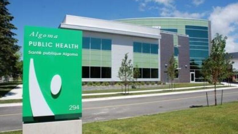 Green sign in front of low-rise office building with green blocks