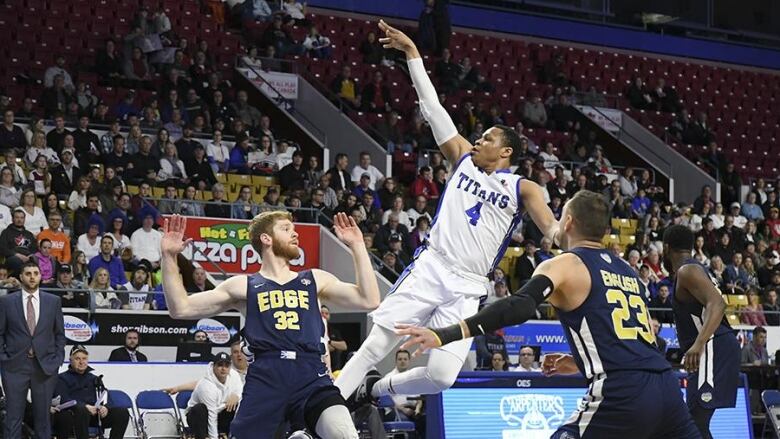 A basketball player jumps to throw the ball toward the basket. 