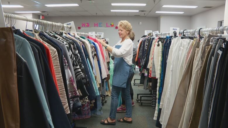 A room full of clothes on a clothing rack.