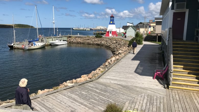 A waterfront is shown with a lighthouse in the background