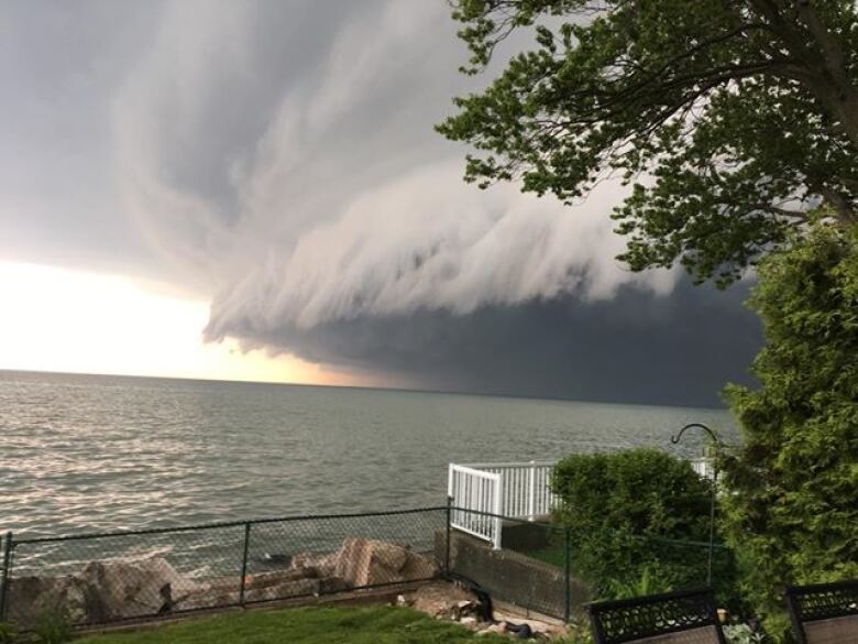 Towering storm clouds over a body of water. 