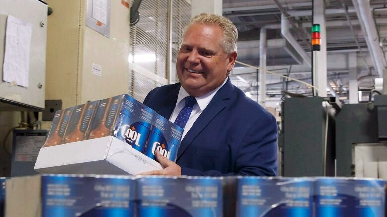 Doug Ford carries a case of Cool Brewery beer.  