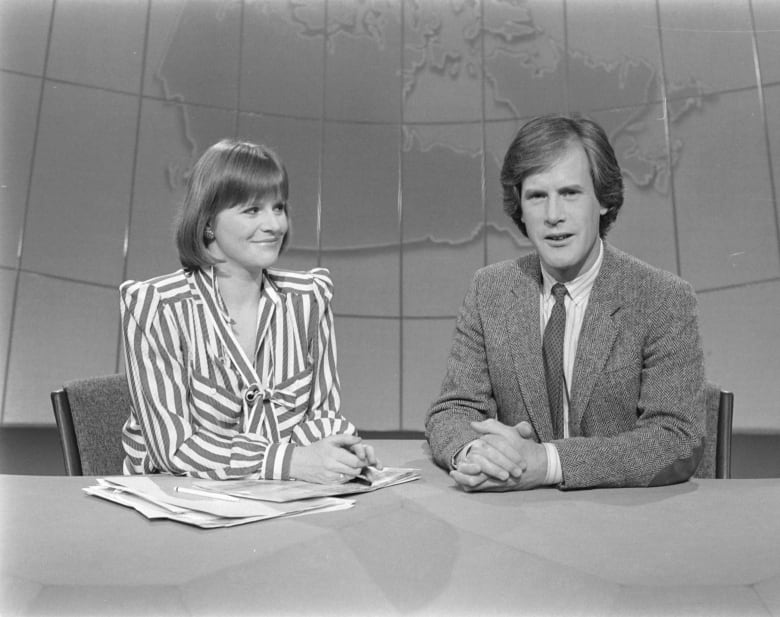 Woman and man at desk on TV set