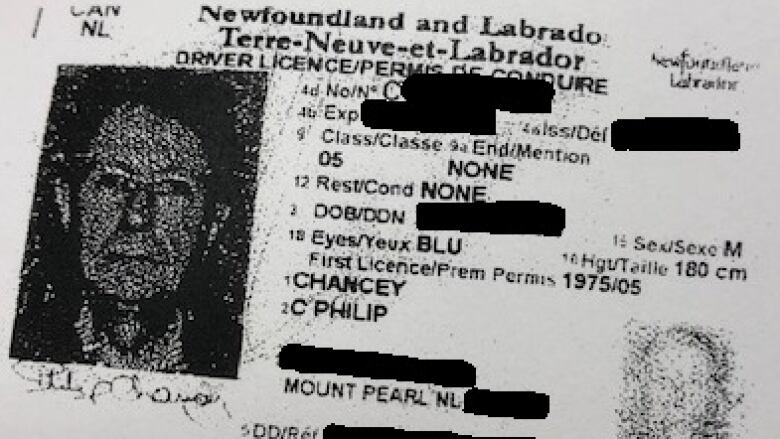 A photo ID with identifying information blacked out.