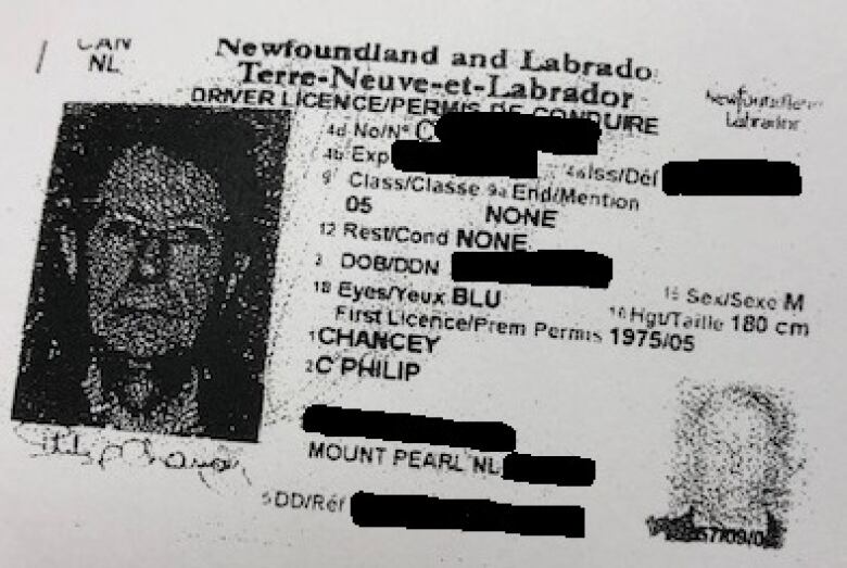 A photo ID with identifying information blacked out.