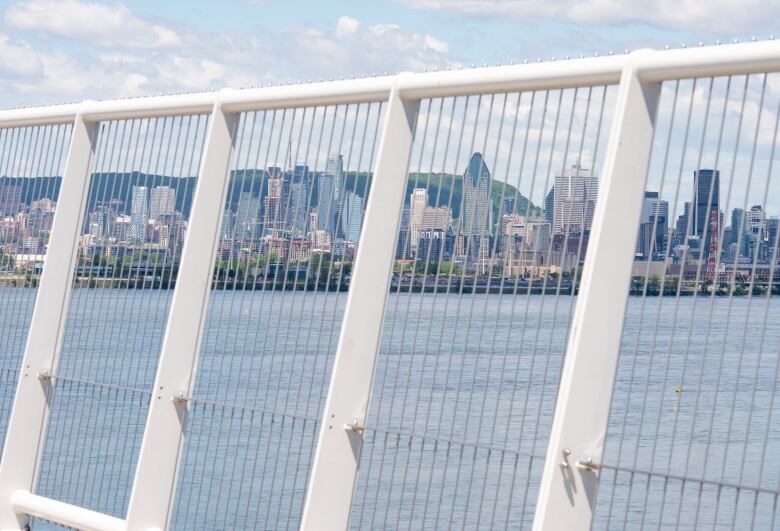 View of Montreal skyline through bridge fencing.