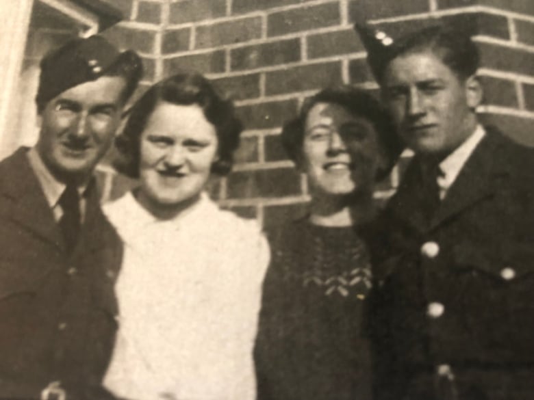 Vintagw black and white photo of two men in air force uniforms and caps flanking two women.