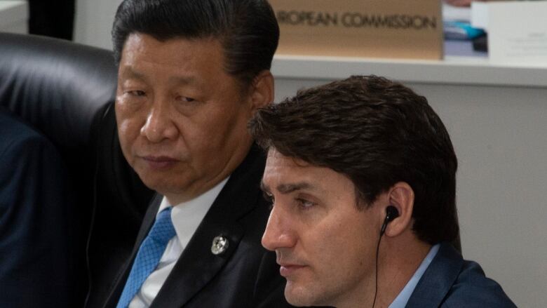 Canadian Prime Minister Justin Trudeau and Chinese President Xi Jinping listen to opening remarks at a plenary session at the G20 Summit in Osaka, Japan, Friday June 28, 2019. 