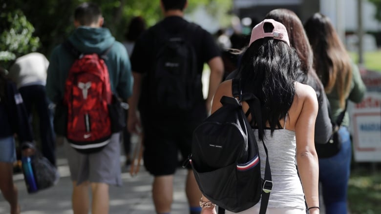 Students walk on the campus of a college.