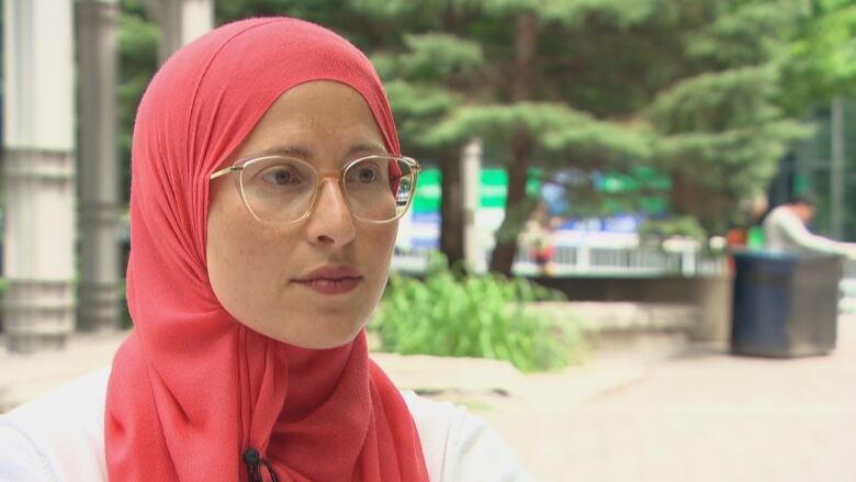 A woman with a headscarf and glasses.