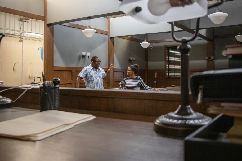 Two people speaking in a courthouse set