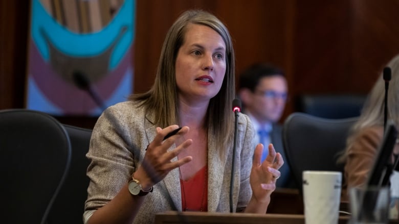 A woman gestures as she speaks in council.