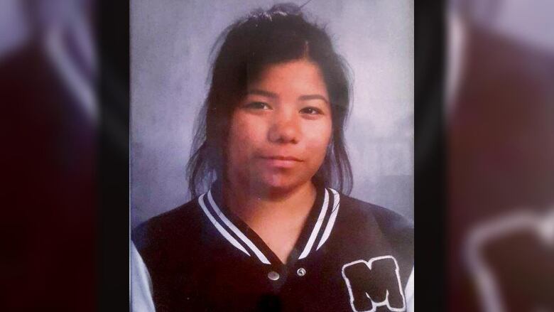 A school photo shows a young woman wearing a school jacket smiling for the camera.