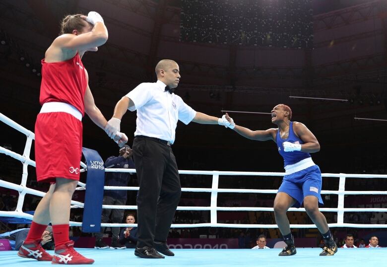 in boxing ring, canadian at left is tired and distraught after losing her match to american athlete at right