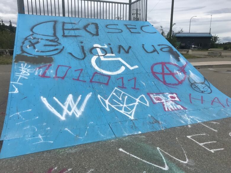 A skateboard ramp covered in graffiti.