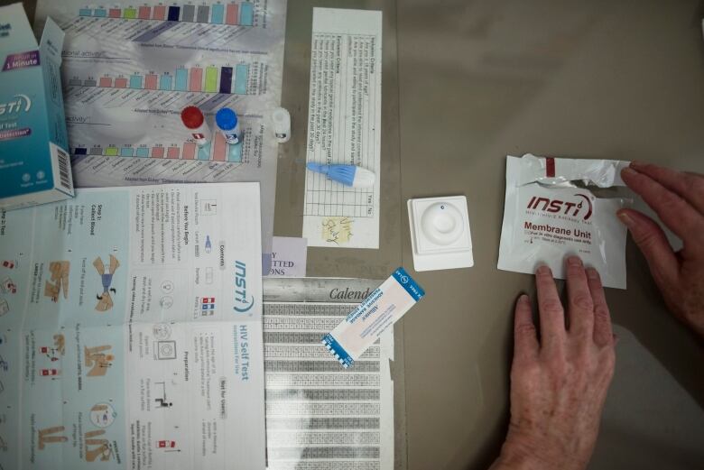 A hand is shown tearing open an INSTI rapid HIV self-test