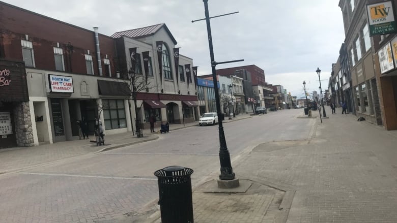 A view of a street with some businesses lining the sidewalks 