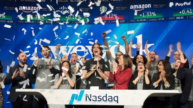 Adam Neumann, center, co-founder and CEO of WeWork, attends the opening bell ceremony at Nasdaq