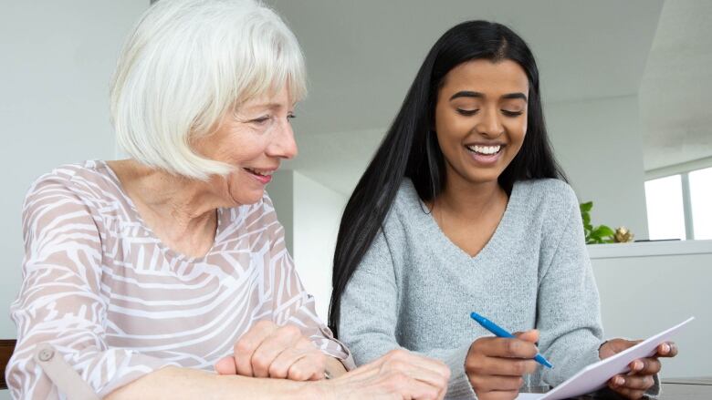 An older person and a younger person sitting together