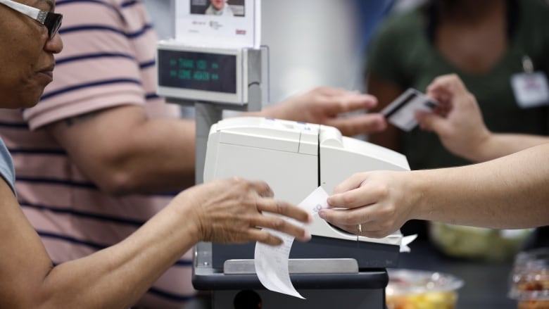 A customer gets a receipt handed to them at a cash register. 