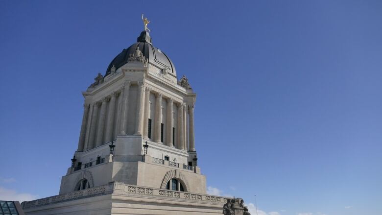 A building is pictured, with a golden statue atop.