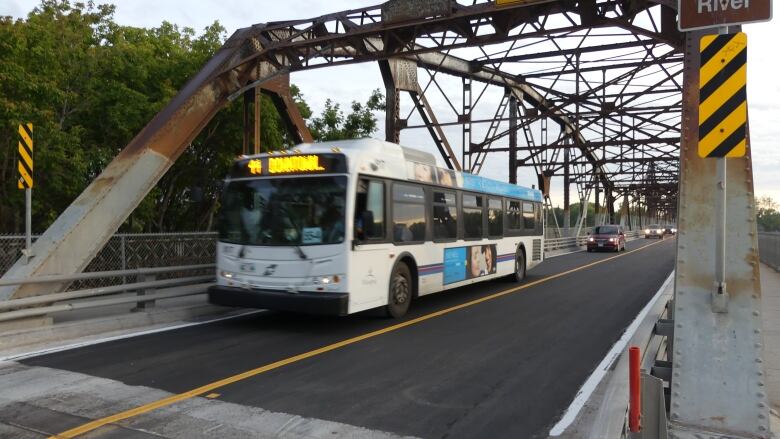 A bus drives on a bridge.