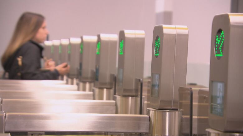 A woman walks through silver fare gates