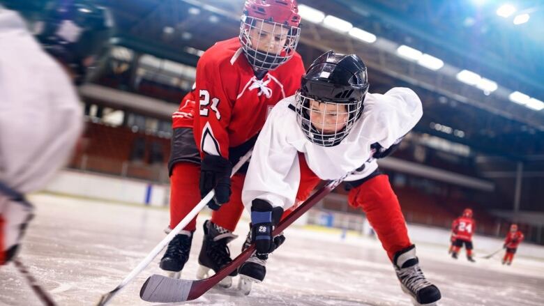 Youth hockey players on an ice rink. 