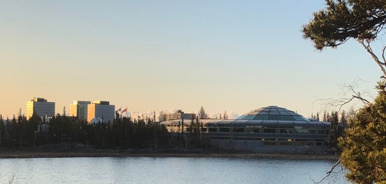 City buildings are seen from afar, across the water.