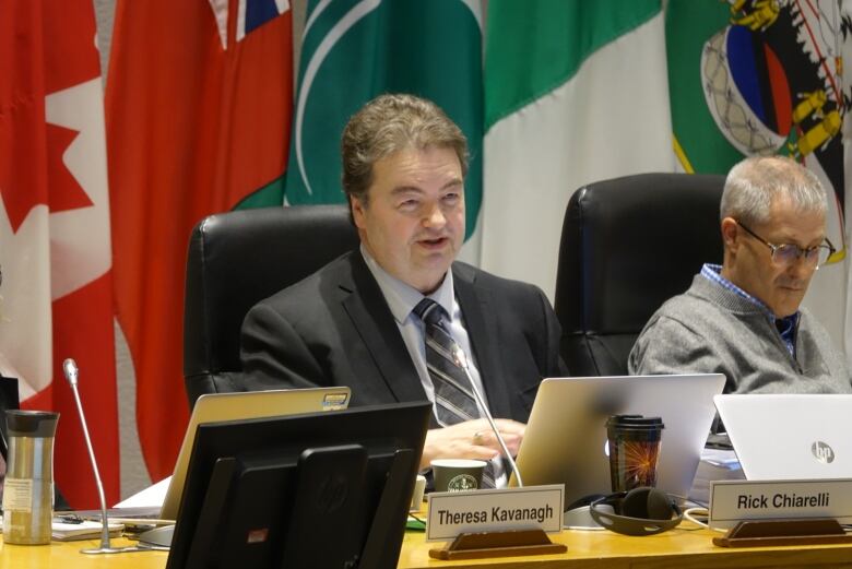 A man sits at the desk in council chambers