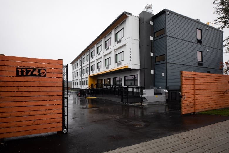 A large white and grey building is pictured on a cloudy day.