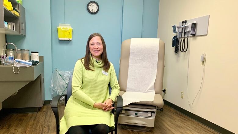 Woman sits on chair in office.