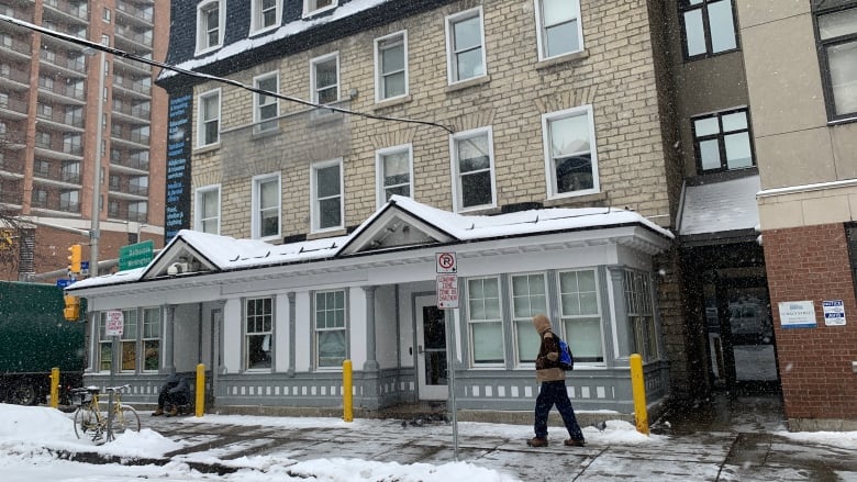 A brick low-rise building in a city in winter.