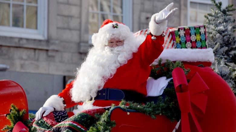 Santa waves to the crowd from a parade float