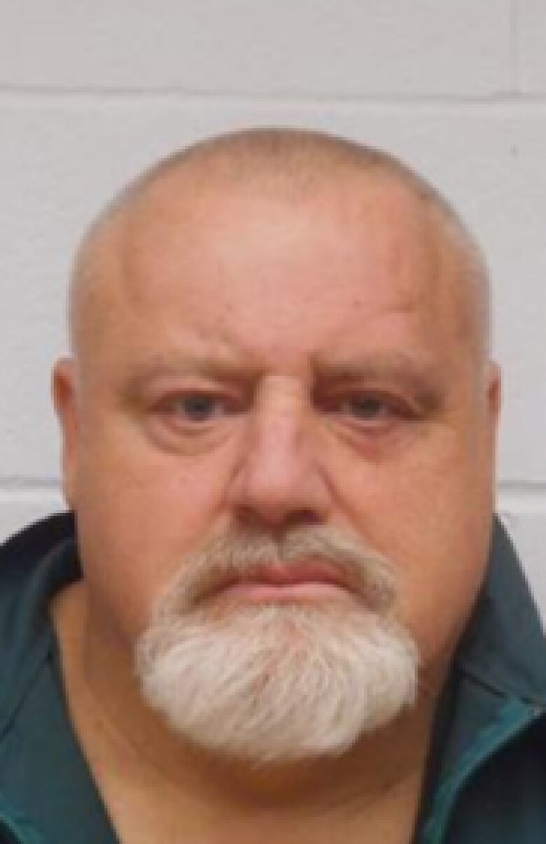 Brian Abrosimo, a white man with a bald head and grey beard, is shown in a mug shot.