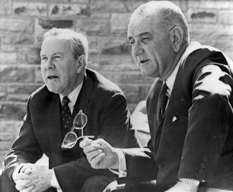 Two men sit outdoors in black-and-white photo