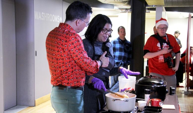 A woman does a cooking demonstration while being interviewed by a man