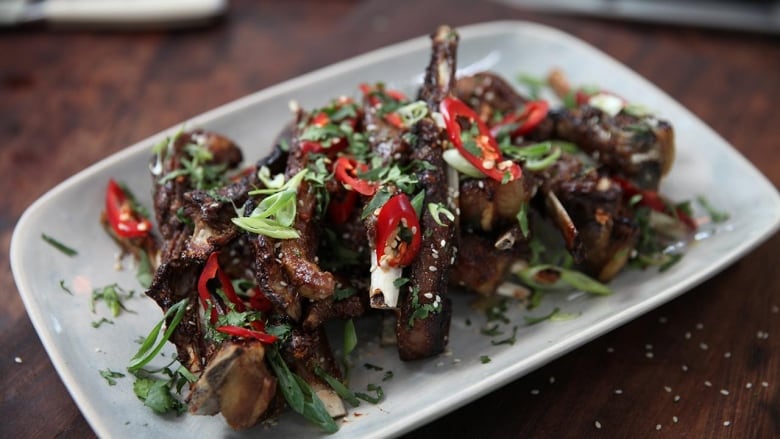 A white platter with lamb ribs. 