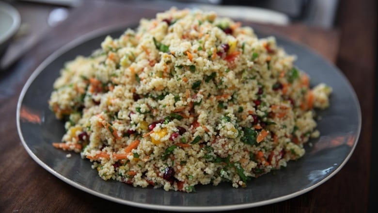 A grey plate with a Pomegranate and Parsley Tabbouleh on it. 