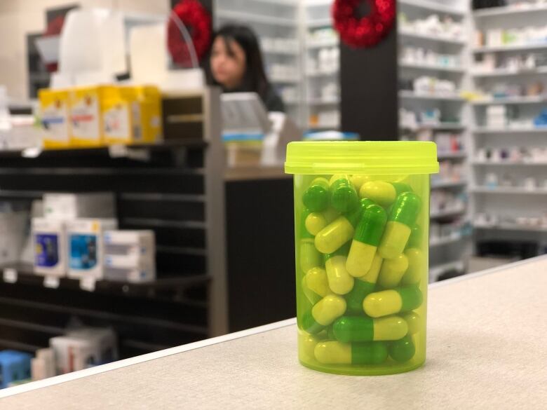 A generic yellow prescription drug bottle is filled with pills.